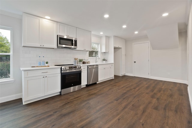 kitchen featuring white cabinets, appliances with stainless steel finishes, light countertops, and a sink