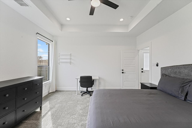 bedroom with a tray ceiling, baseboards, visible vents, and carpet flooring