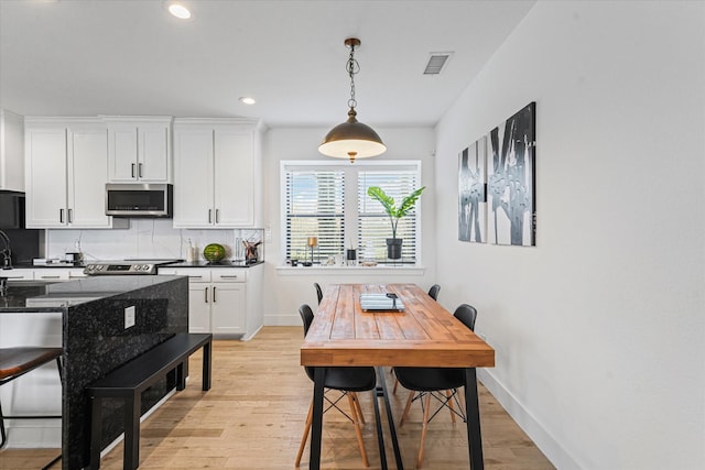 dining area with visible vents, baseboards, and light wood-style floors