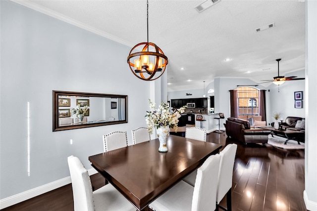 dining area with ceiling fan with notable chandelier, wood finished floors, visible vents, and baseboards