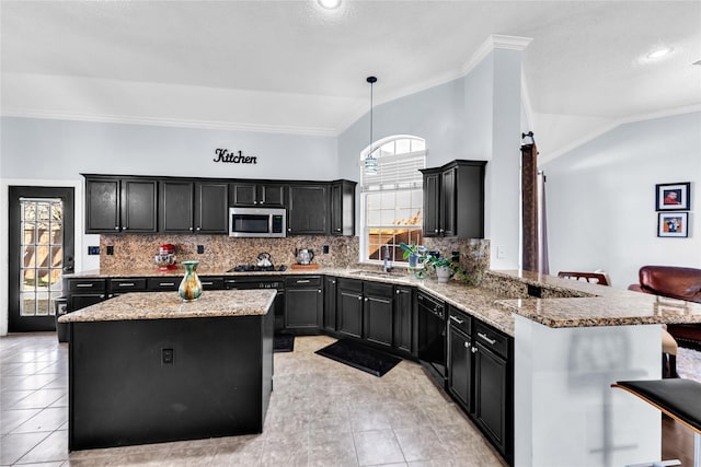 kitchen featuring dark cabinetry, stainless steel microwave, tasteful backsplash, and a kitchen island