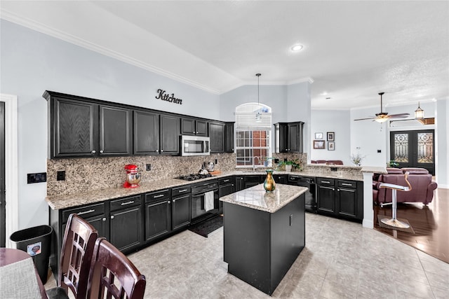 kitchen featuring stainless steel microwave, a peninsula, dark cabinets, and black gas stovetop