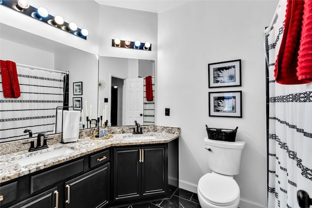 full bathroom with double vanity, toilet, baseboards, and a sink