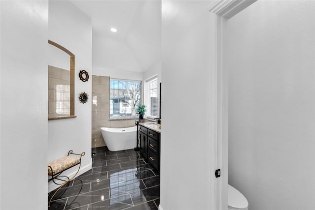 full bathroom featuring recessed lighting, a soaking tub, vanity, and toilet