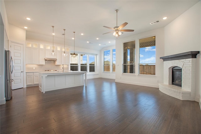 unfurnished living room with recessed lighting, visible vents, dark wood-style flooring, and a fireplace