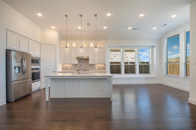 kitchen featuring visible vents, dark wood finished floors, light countertops, decorative backsplash, and appliances with stainless steel finishes