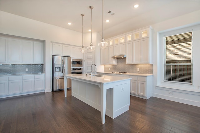 kitchen with visible vents, an island with sink, light countertops, stainless steel appliances, and a sink