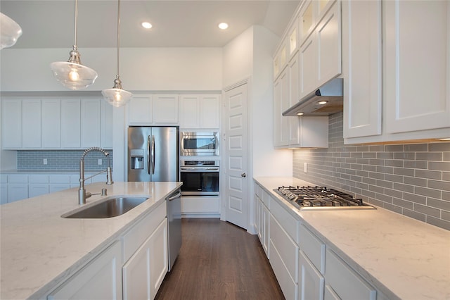 kitchen with a sink, stainless steel appliances, under cabinet range hood, and white cabinetry