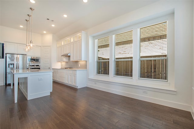 kitchen featuring tasteful backsplash, visible vents, a sink, stainless steel appliances, and dark wood-style flooring