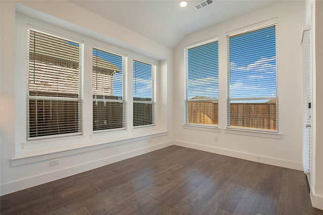 spare room featuring dark wood-style floors, baseboards, visible vents, recessed lighting, and vaulted ceiling