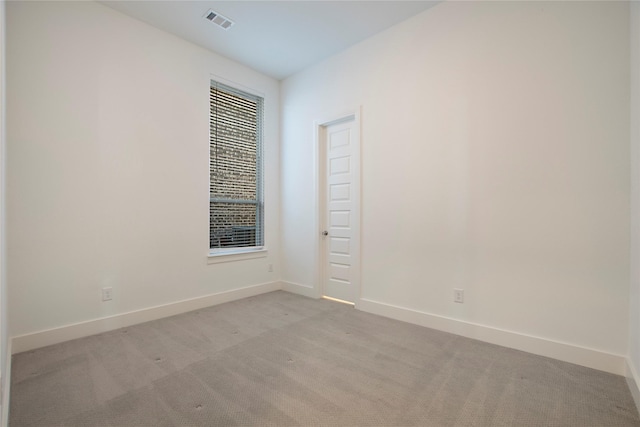 unfurnished room with light carpet, visible vents, and baseboards