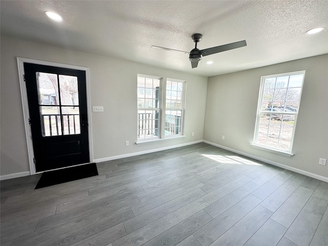 foyer with dark wood finished floors, recessed lighting, and baseboards