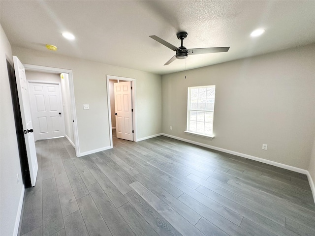 unfurnished bedroom featuring dark wood-style floors, baseboards, recessed lighting, ceiling fan, and a textured ceiling