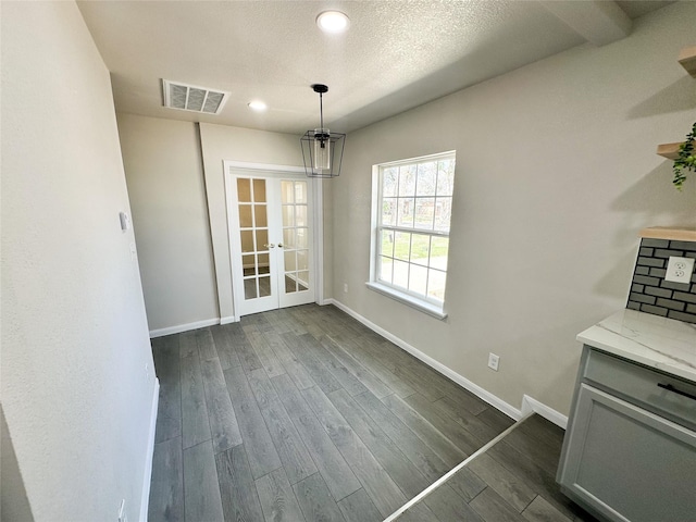 unfurnished dining area featuring visible vents, baseboards, dark wood finished floors, recessed lighting, and french doors