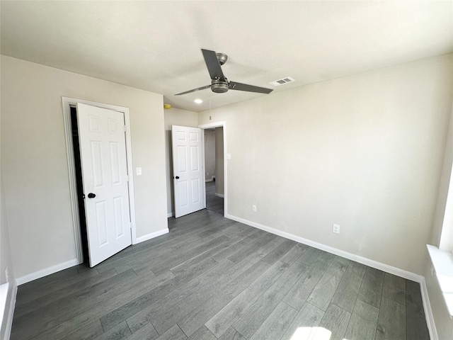 unfurnished bedroom featuring visible vents, baseboards, dark wood-type flooring, and ceiling fan