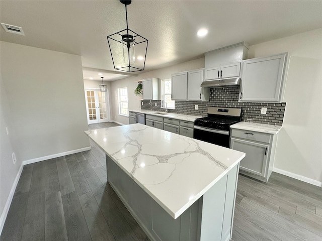 kitchen with tasteful backsplash, wood finished floors, visible vents, and appliances with stainless steel finishes