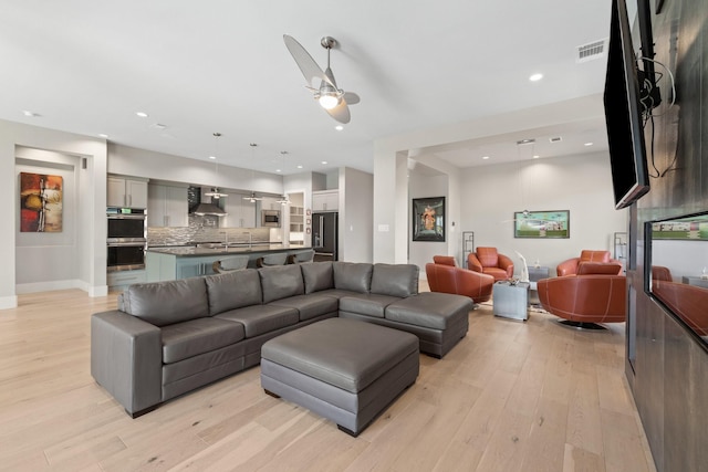 living area with visible vents, recessed lighting, and light wood-type flooring