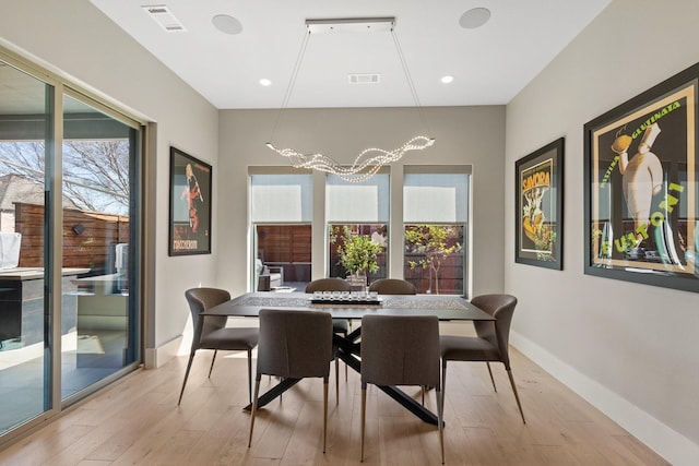 dining room with visible vents, baseboards, and light wood-style floors