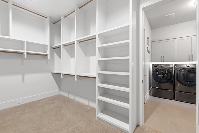 interior space featuring washer and dryer, visible vents, and light carpet