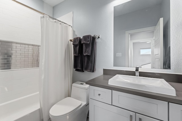 bathroom with shower / bathtub combination with curtain, toilet, vanity, and a textured wall