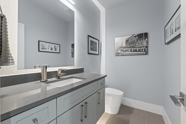 bathroom with tile patterned flooring, toilet, vanity, and baseboards