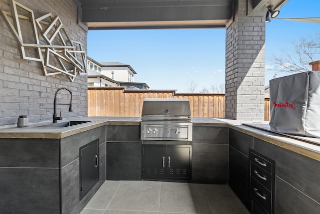 view of patio featuring a sink, area for grilling, exterior kitchen, and fence