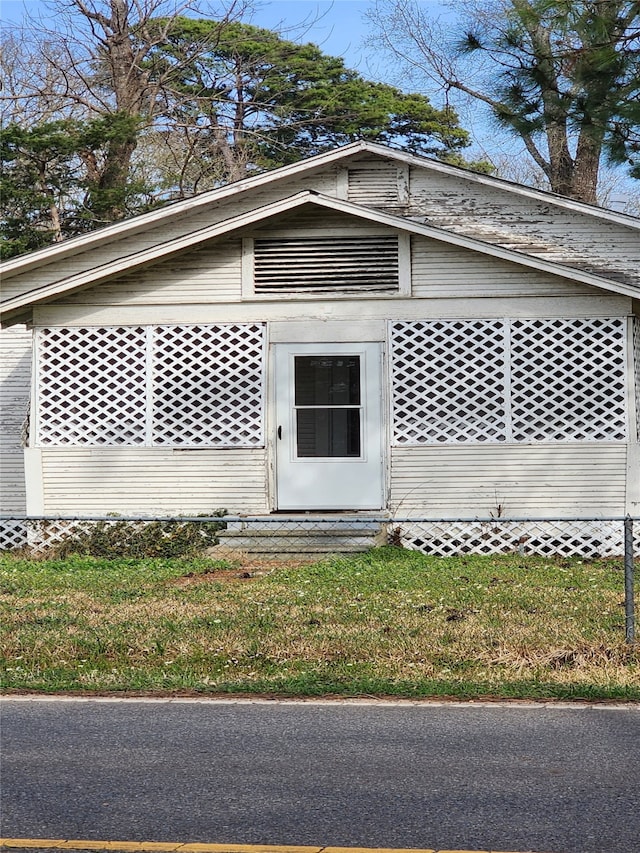 view of exterior entry with a yard