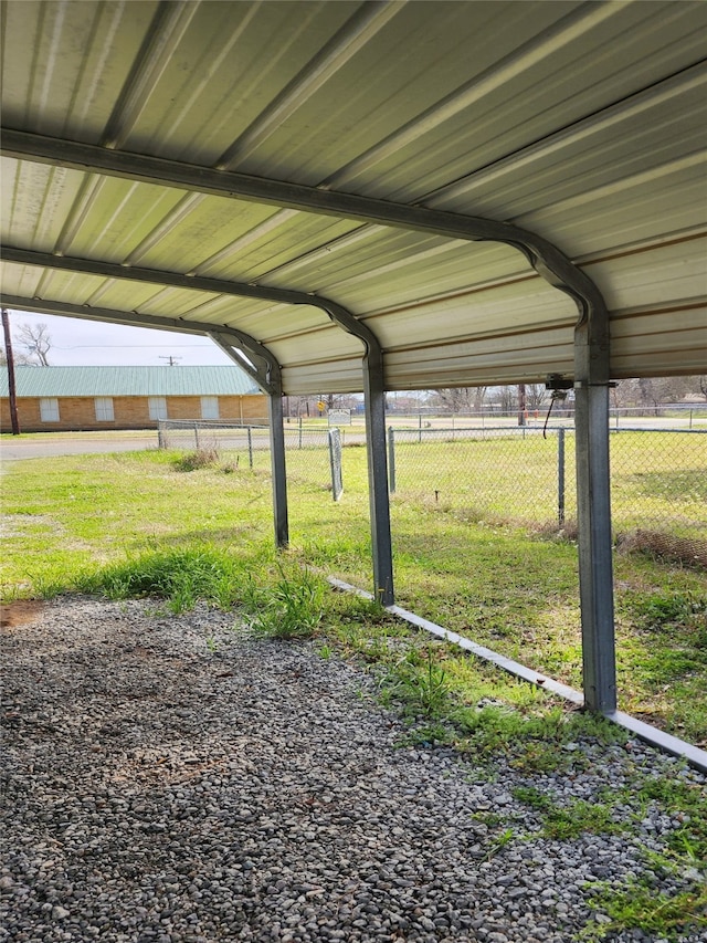 view of parking with a detached carport and fence