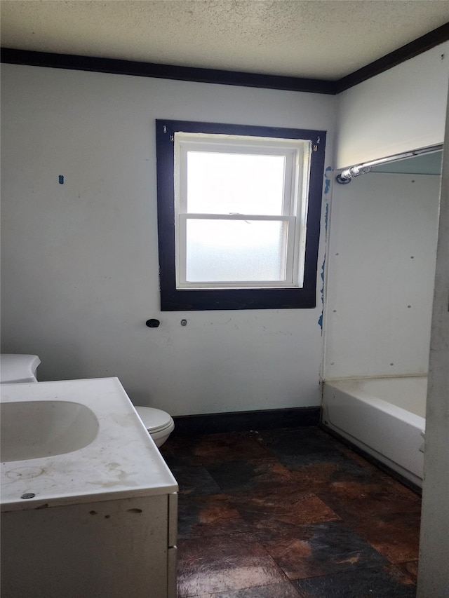 full bath featuring a tub, toilet, vanity, and a textured ceiling