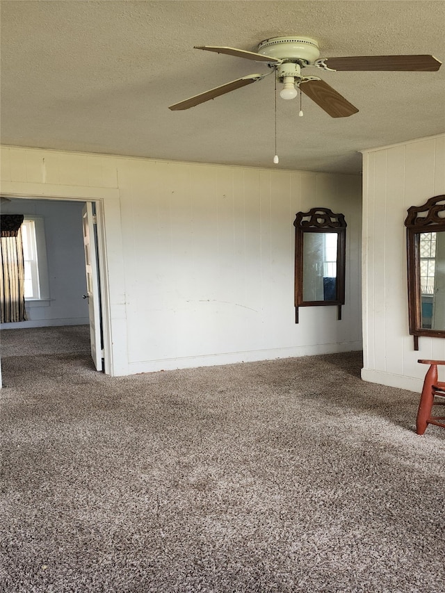 unfurnished room with ceiling fan, carpet, and a textured ceiling