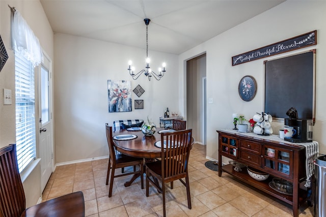 dining area with light tile patterned floors, baseboards, and a chandelier