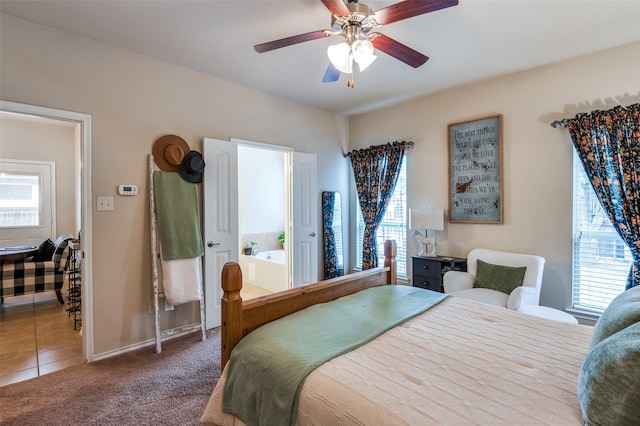 carpeted bedroom with baseboards, ceiling fan, ensuite bathroom, and tile patterned flooring