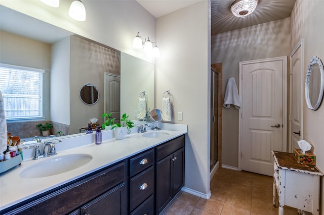 full bathroom featuring a sink, a shower stall, tile patterned floors, and double vanity