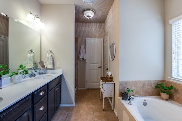 bathroom with baseboards, a garden tub, vanity, and tile patterned flooring