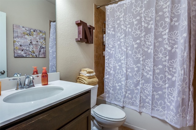 full bathroom with vanity, toilet, a textured wall, and shower / bath combo with shower curtain