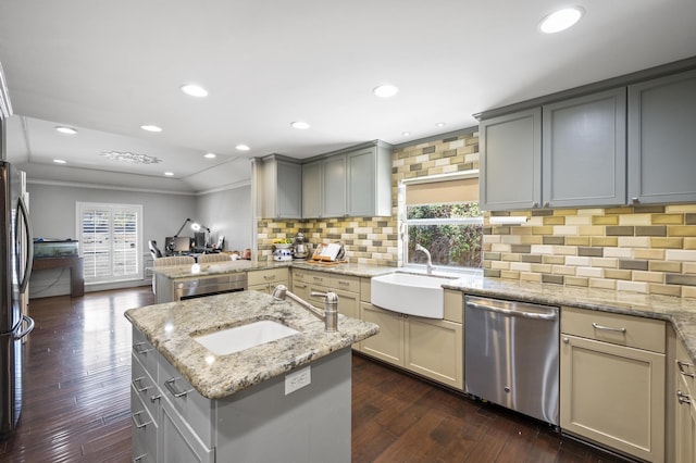 kitchen featuring a healthy amount of sunlight, a peninsula, gray cabinets, a sink, and stainless steel dishwasher