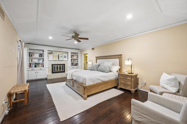 bedroom with baseboards, a ceiling fan, a glass covered fireplace, and dark wood-style flooring