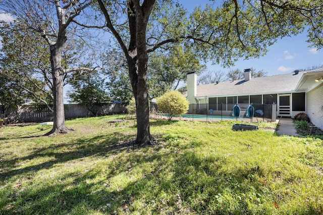 view of yard with a fenced in pool, a fenced backyard, and a sunroom