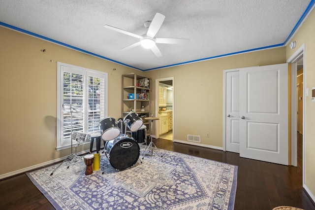 interior space with visible vents, a textured ceiling, ceiling fan, and wood finished floors