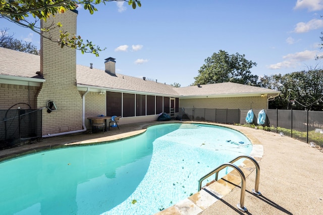 view of pool featuring a patio area, fence, a fenced in pool, and a sunroom