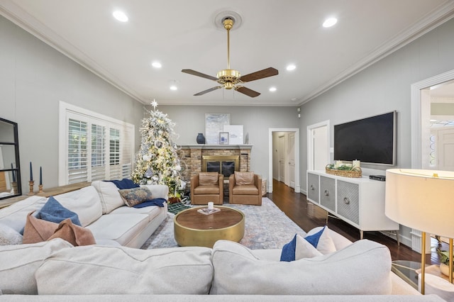 living room featuring recessed lighting, a brick fireplace, wood finished floors, and ornamental molding