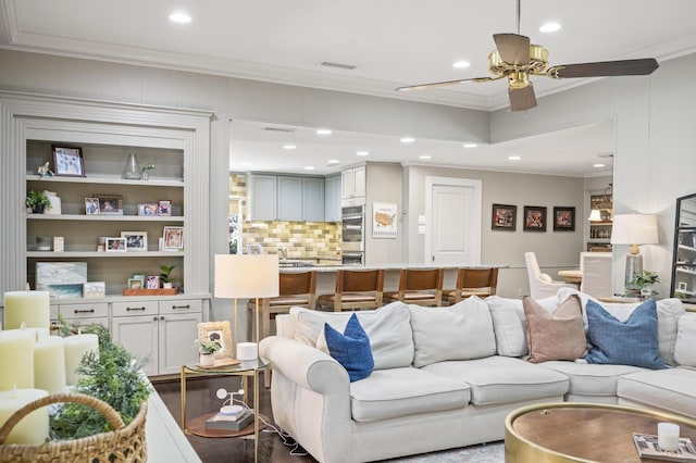 living area with dark wood finished floors, crown molding, recessed lighting, and visible vents