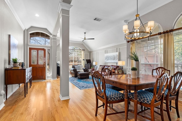 dining area with visible vents, light wood-style flooring, ceiling fan with notable chandelier, lofted ceiling, and ornate columns