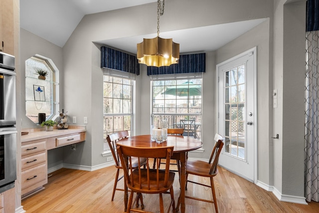 dining area featuring light wood-style flooring, baseboards, a wealth of natural light, and built in desk