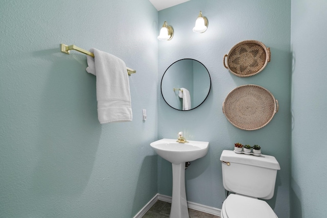 half bathroom featuring toilet and baseboards