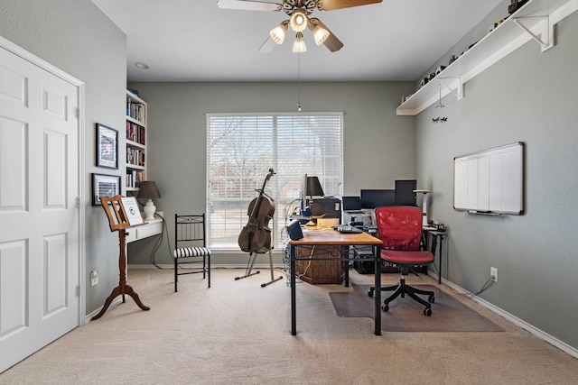 carpeted home office featuring baseboards and a ceiling fan