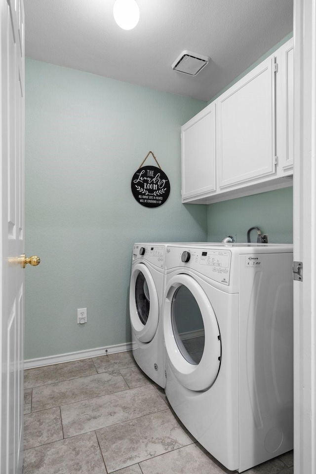 laundry room featuring washer and dryer, visible vents, cabinet space, and baseboards