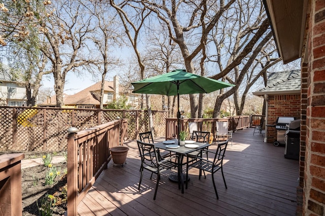 wooden terrace with outdoor dining space and grilling area