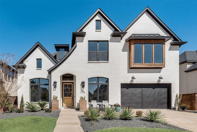 french country home featuring concrete driveway, a garage, and brick siding