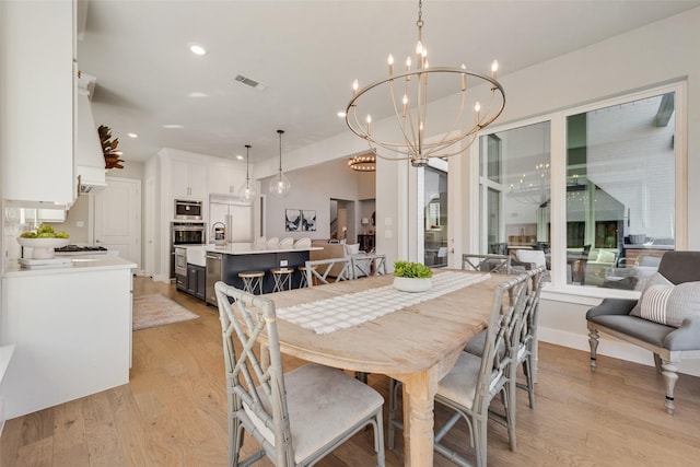 dining space featuring visible vents, light wood finished floors, baseboards, an inviting chandelier, and recessed lighting